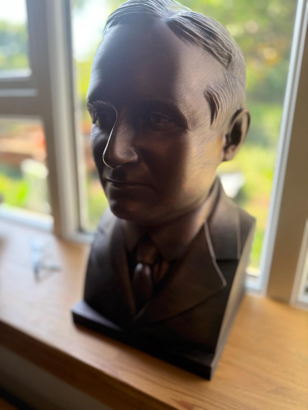 Buyer-submitted charcoal portrait bust displayed beside a window