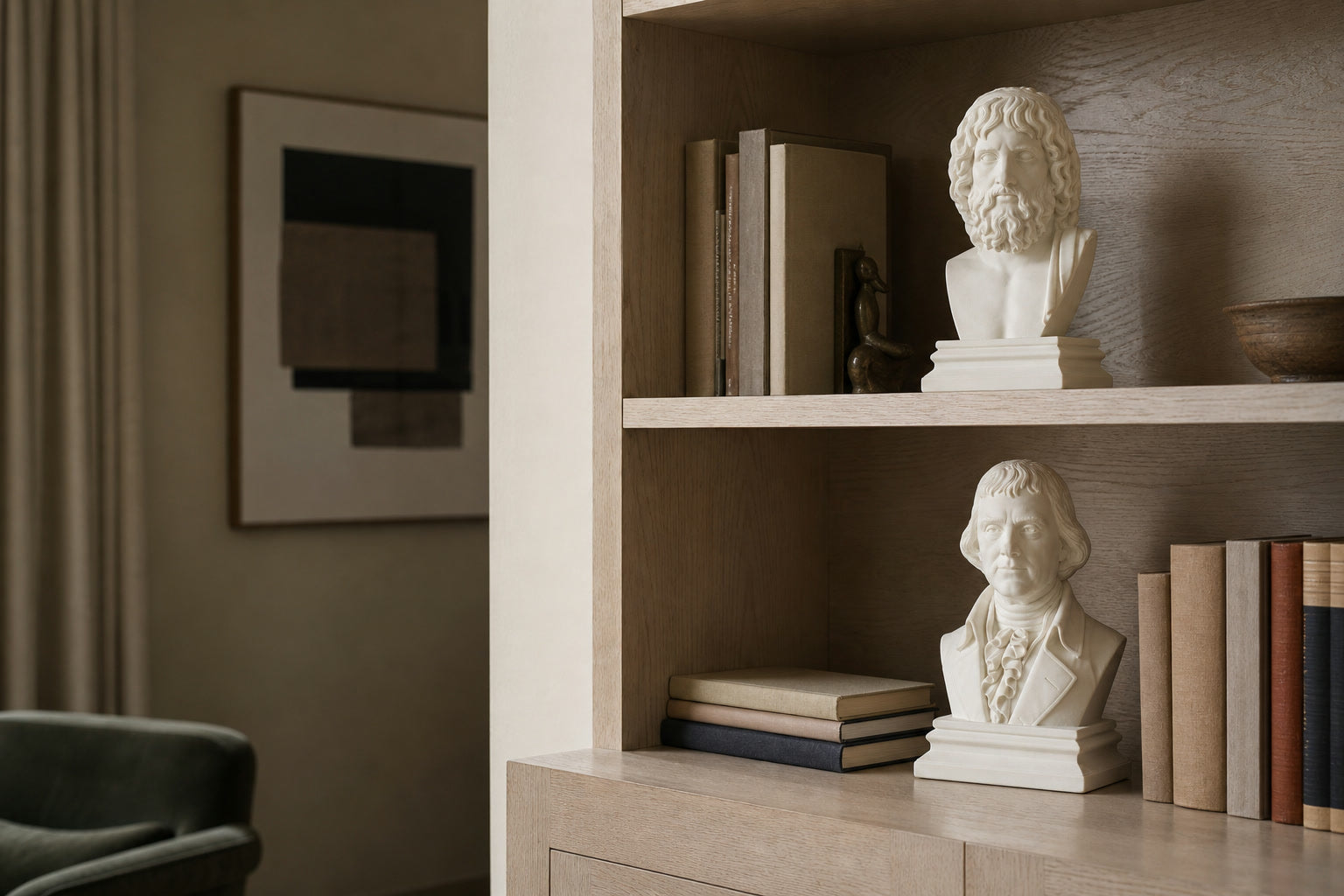 Ivory Hades and Thomas Jefferson busts displayed on light oak shelves in a collector's home